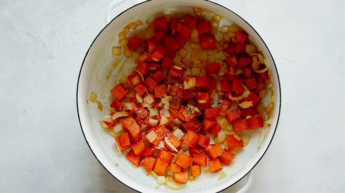 Sweet potato and onion cooking in a stock pot to make tortelli soup.