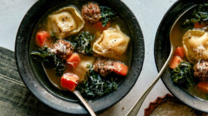 Tortellini Soup recipe in two bowls with spoons next to it.