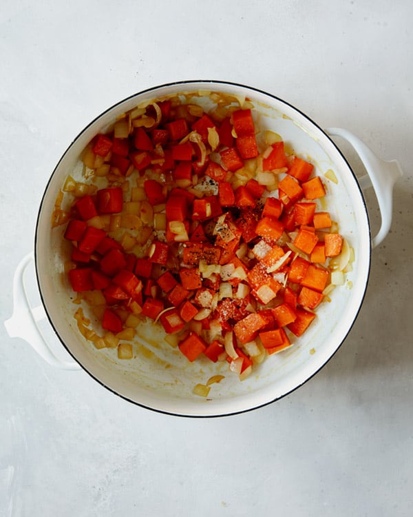 Sweet potato and onion cooking in a stock pot to make tortelli soup.