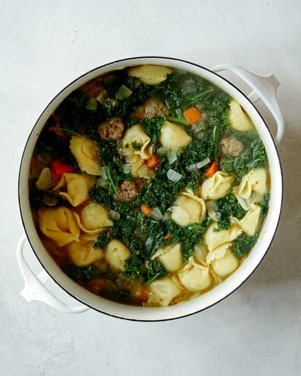 Tortellini soup ready to serve in a stock pot.