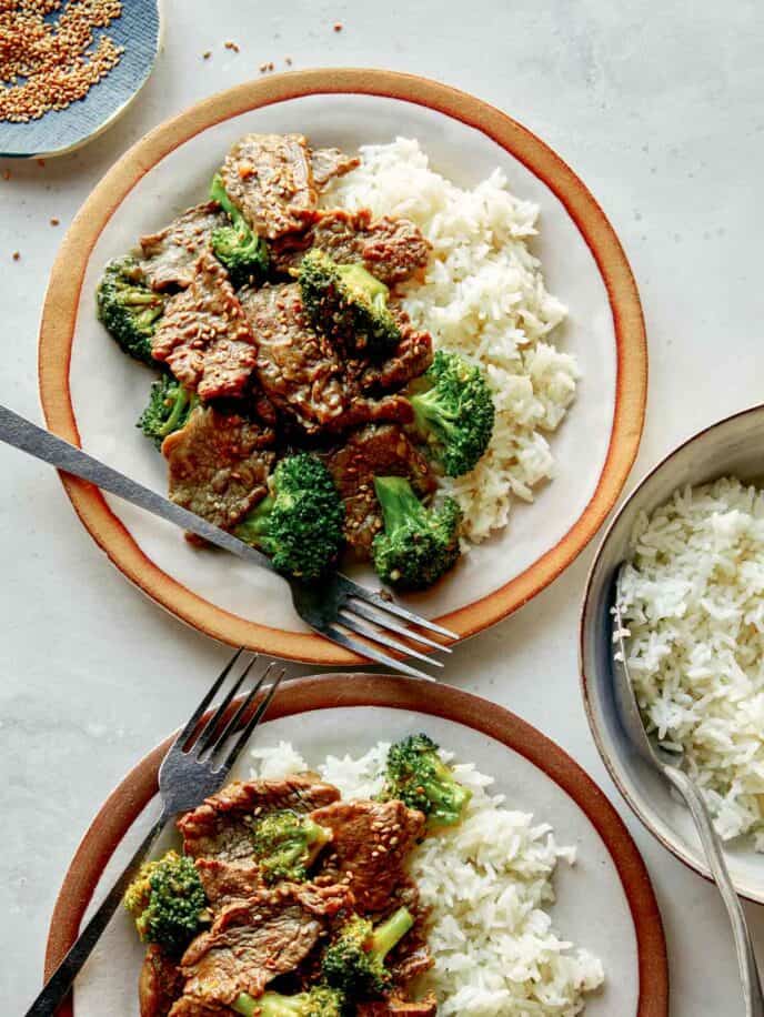 Beef and broccoli on plates with rice. 