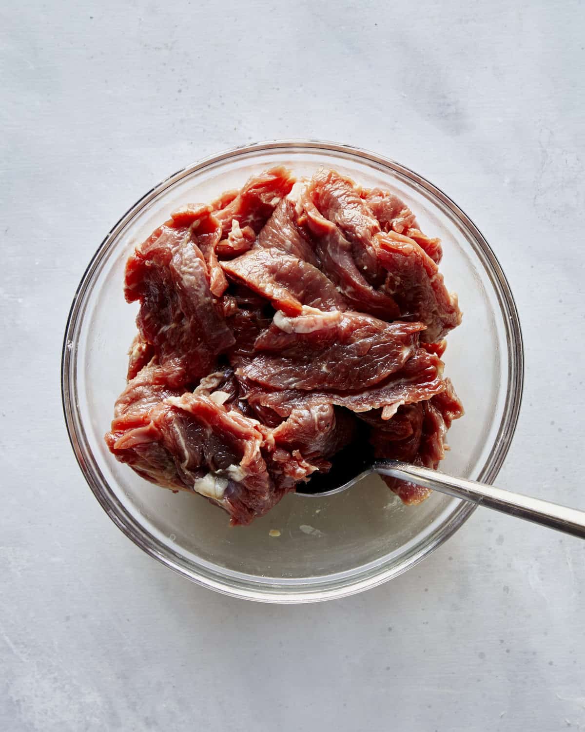 Let beef marinate in a glass bowl.