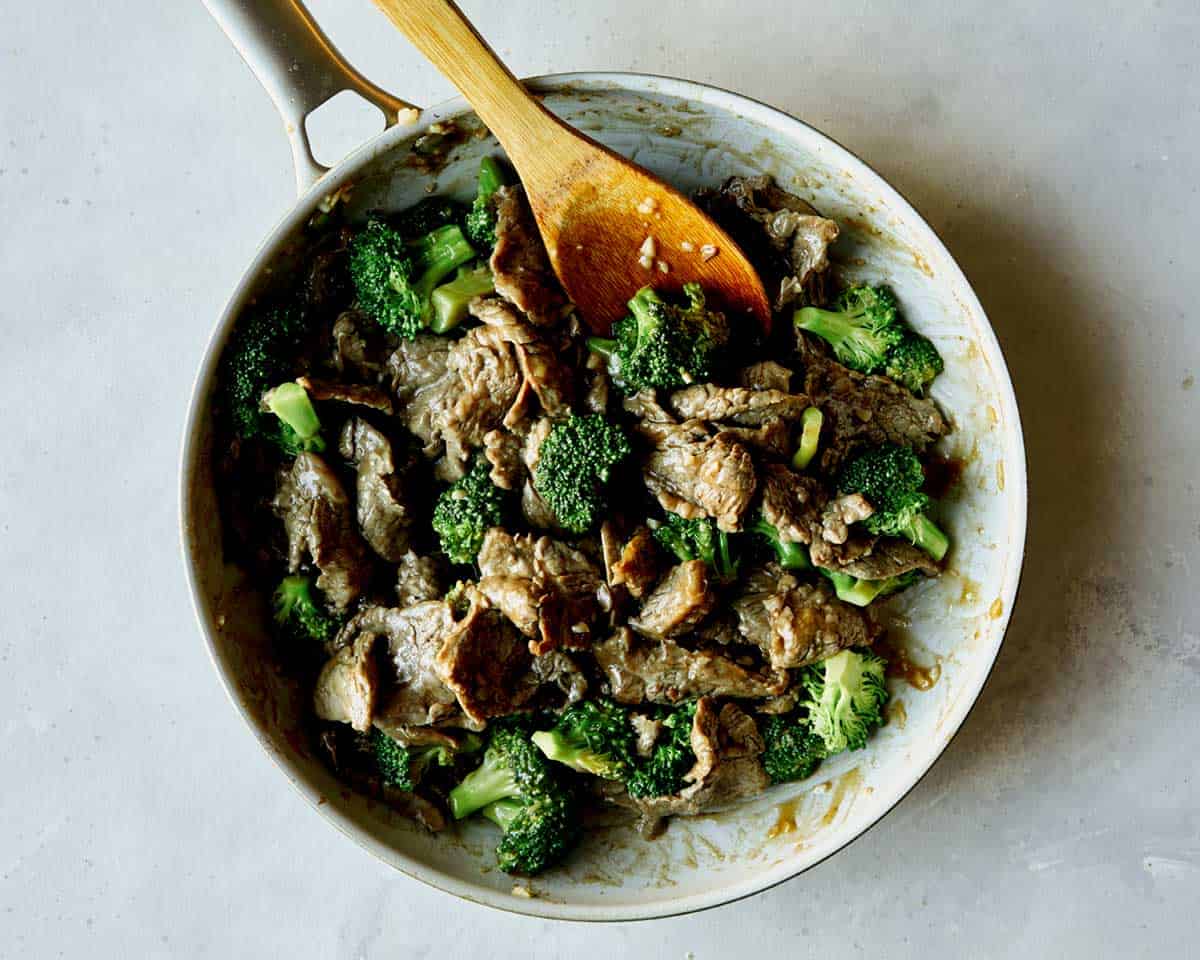 Beef and broccoli with sauce in a skillet.