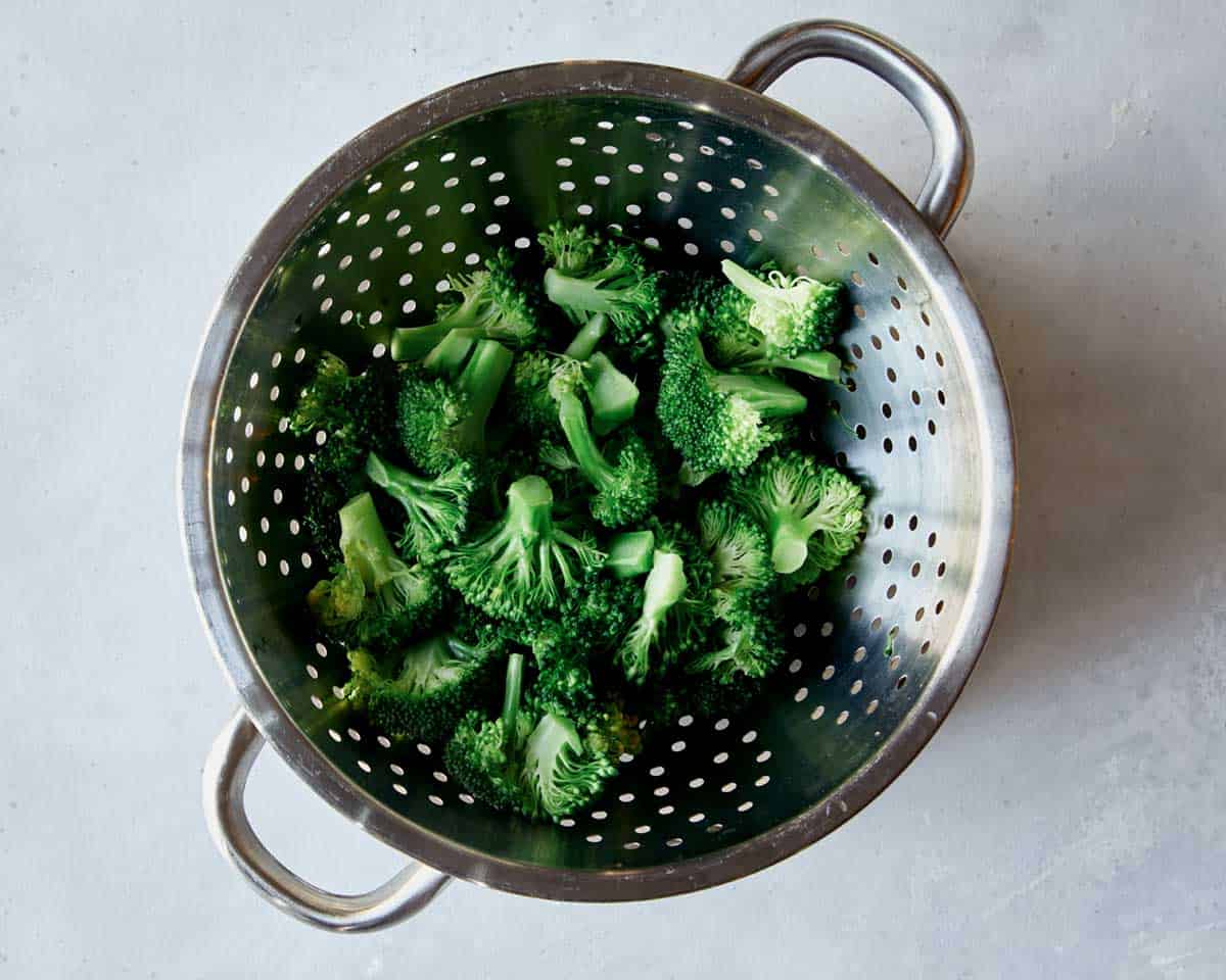 Boiled broccoli in a colander.
