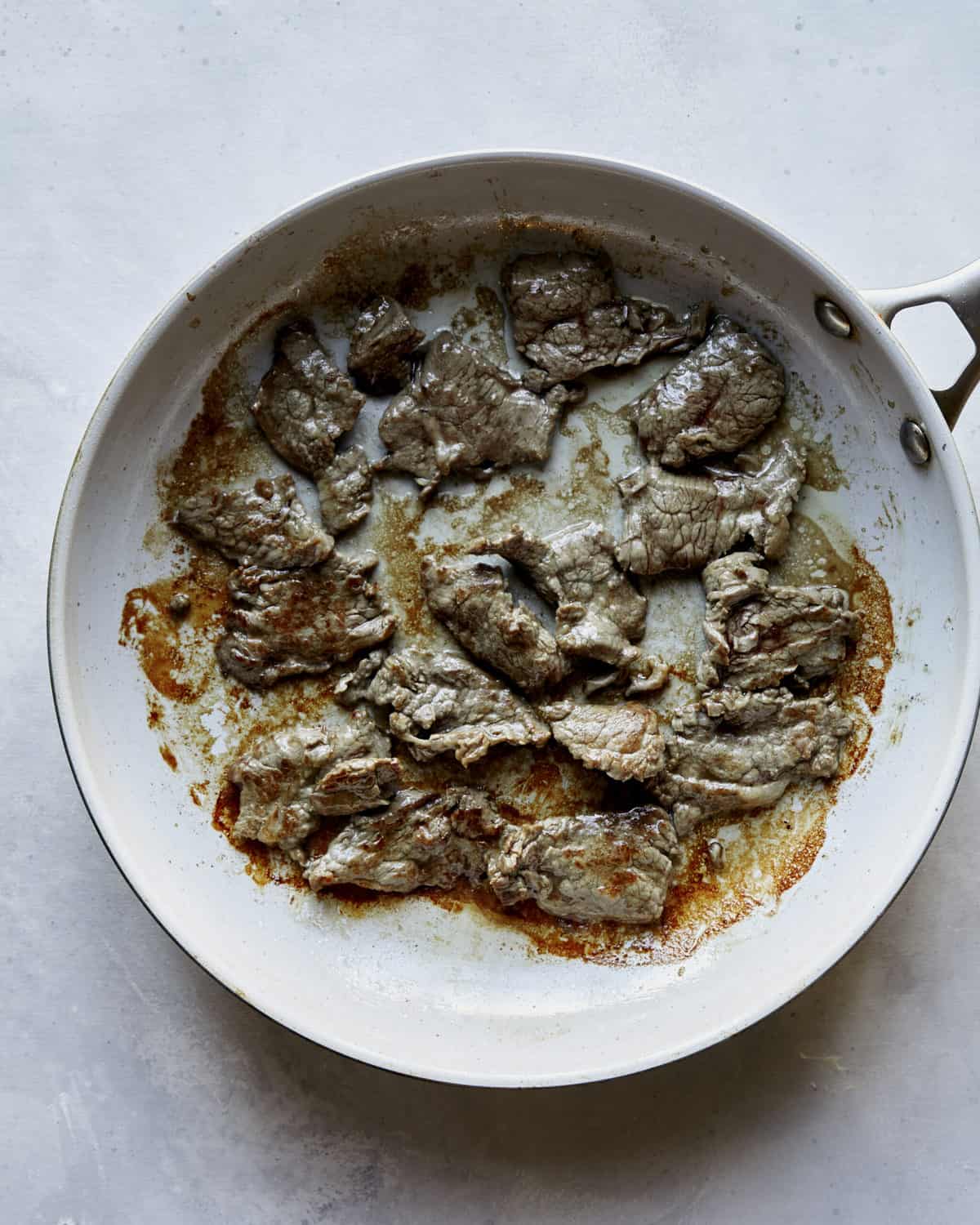 Beef cooking in a skillet for Beef and Broccoli. 