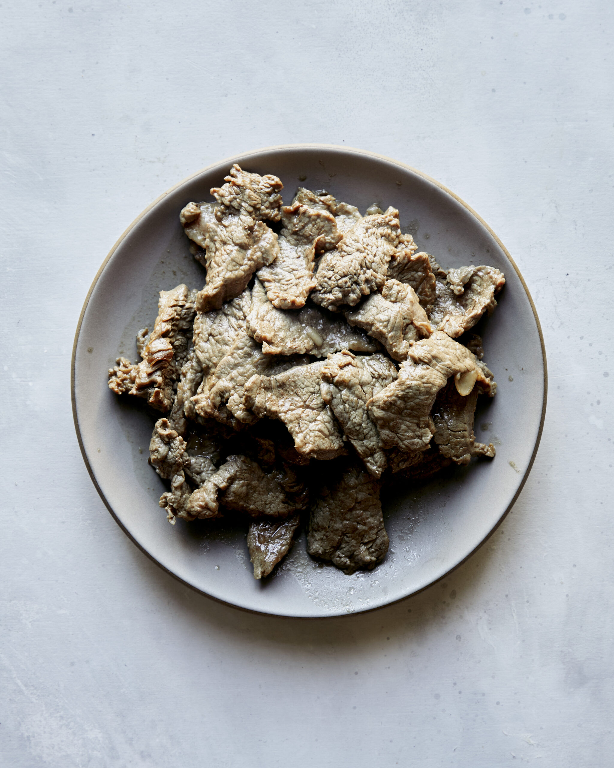 Cooked beef resting on a plate. 