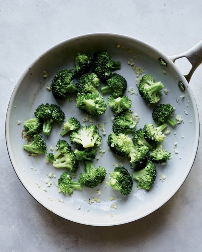 Broccoli and garlic cooking in a skillet. 