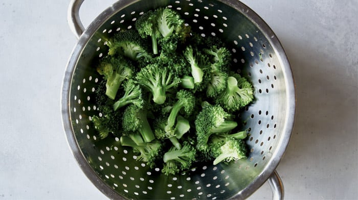 Boiled broccoli in a colander.