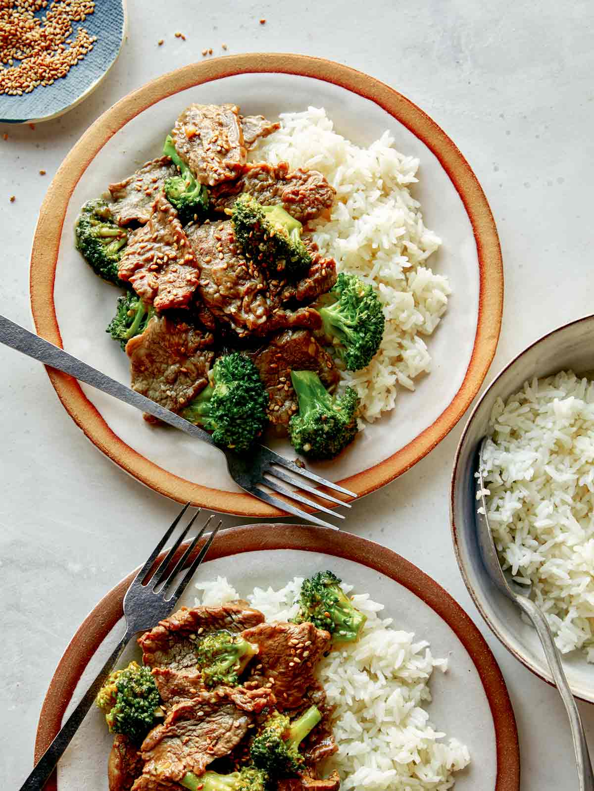 Beef and broccoli on plates with rice.