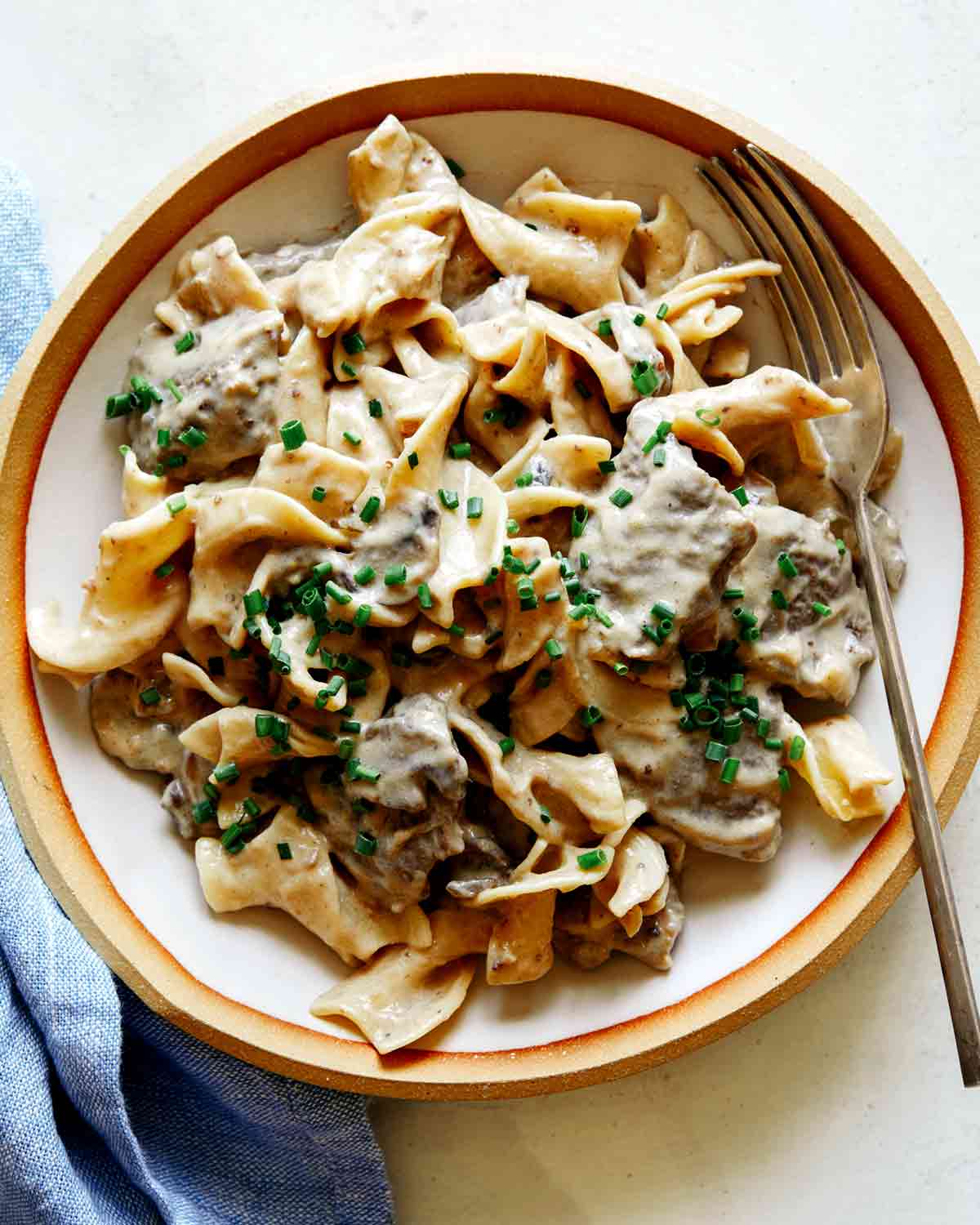 Beef Stroganoff recipe in a bowl with chives on top.