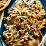 Beef Stroganoff on a platter with chives on top.