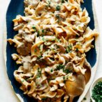 Beef Stroganoff on a platter with chives on top.