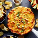 Buffalo Chicken Dip in a skillet with green onions on top.