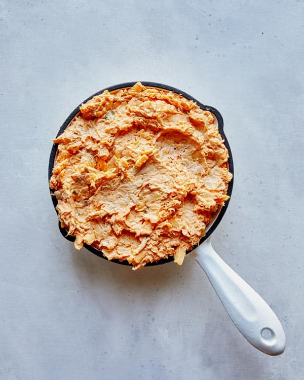 Buffalo Chicken Dip in a skillet before it's baked.