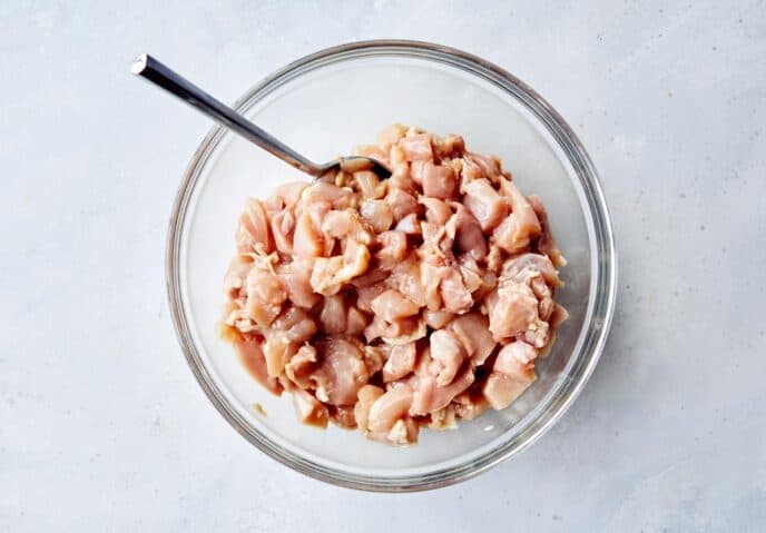 Cashew chicken marinated in a bowl.