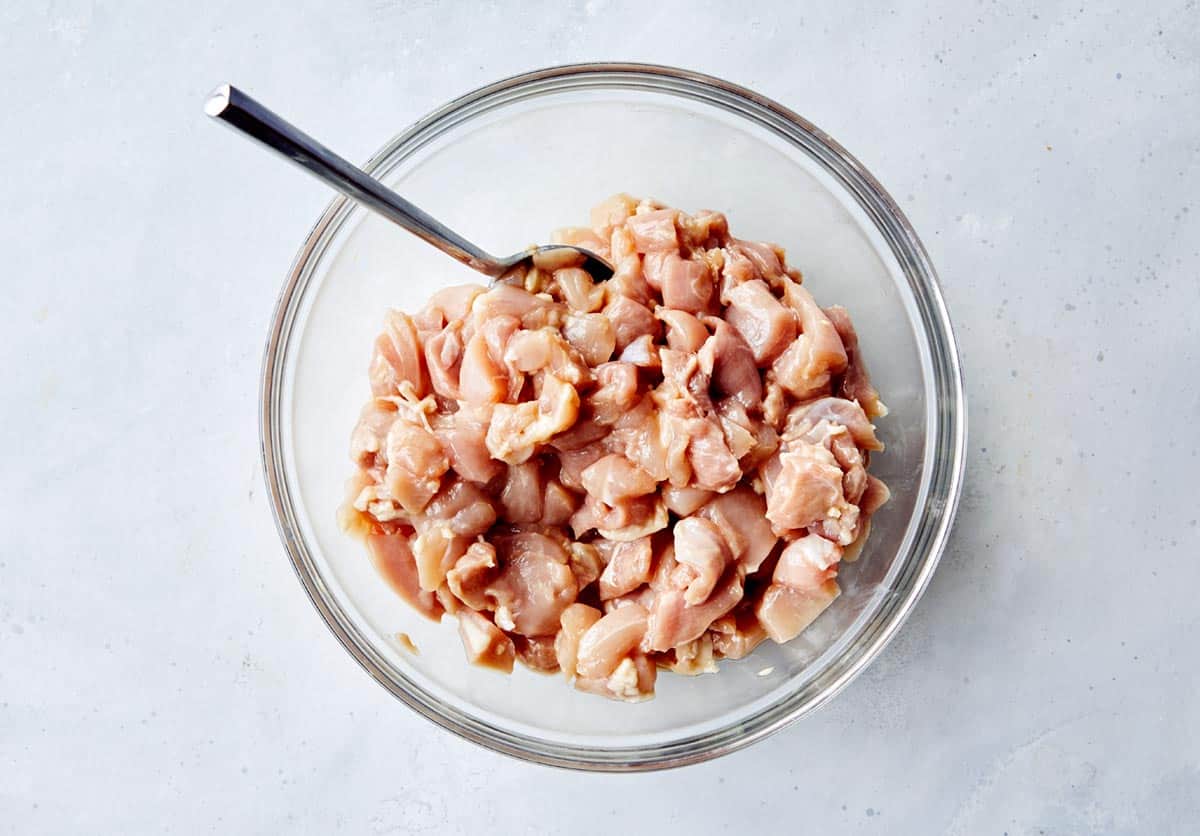 Cashew chicken marinated in a bowl.