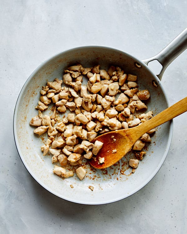 Chicken in a skillet cooking to make cashew chicken.
