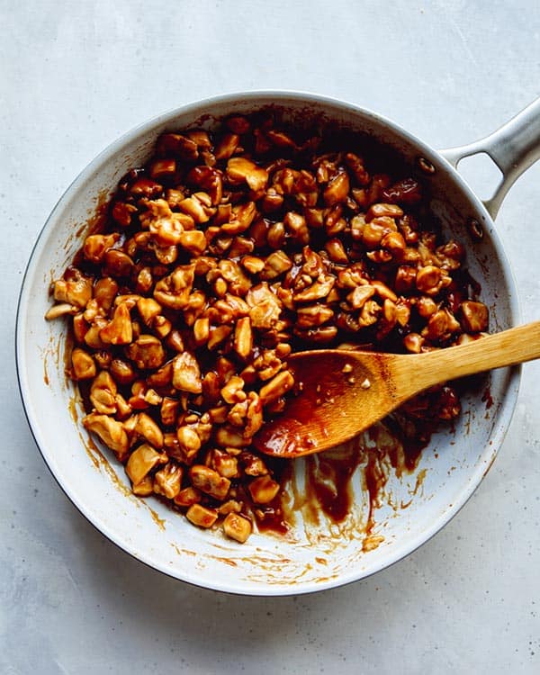 Cashew chicken in a skillet with sauce.