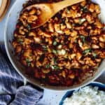 Cashew chicken recipe in a skillet with rice on the side.