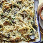 Chicken tetrazzini in a baking dish with a spoon in it.