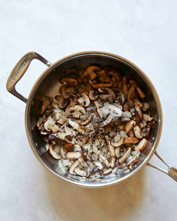 Mushrooms cooking in a skillet.