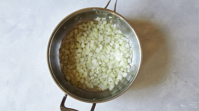 Onions cooking in a skillet with butter.