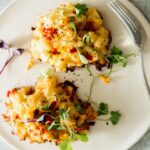 A freshly made crab cake recipe on a plate with a fork.