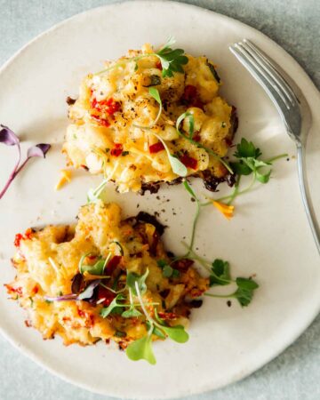 A freshly made crab cake recipe on a plate with a fork.