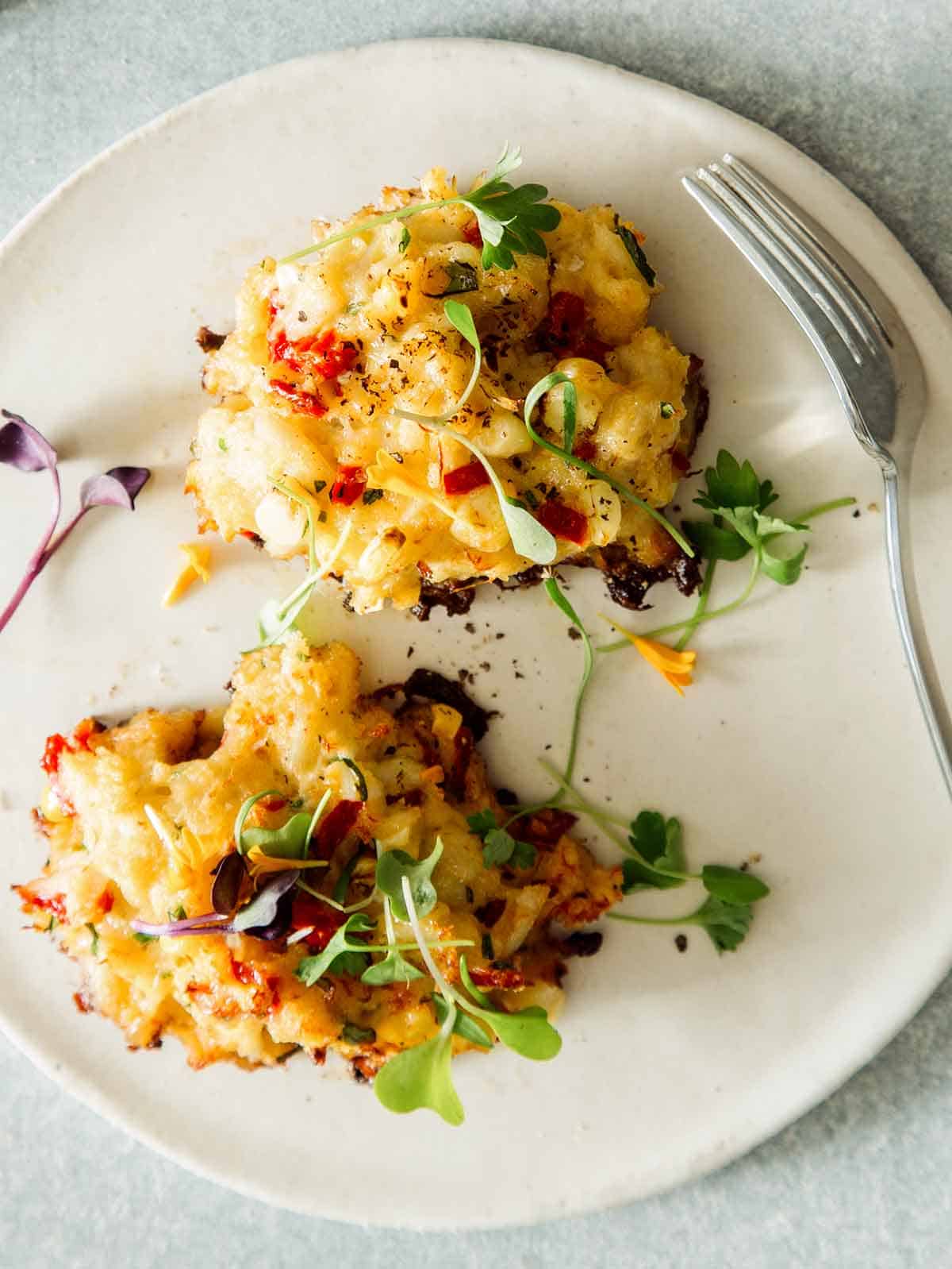 A freshly made crab cake recipe on a plate with a fork.