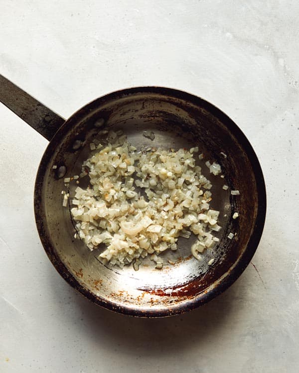 Sauté shallots and garlic in a skillet.