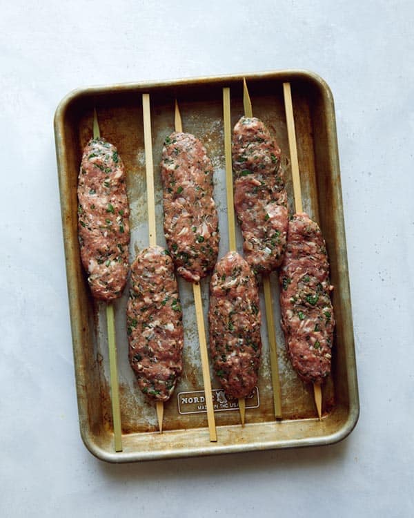 Ground lamb formed onto skewers to be grilled to make Lamb Kofta.