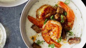 Shrimp and grits in a bowl with green onions on top.