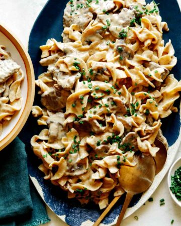 Beef Stroganoff recipe on a platter with chives on top.