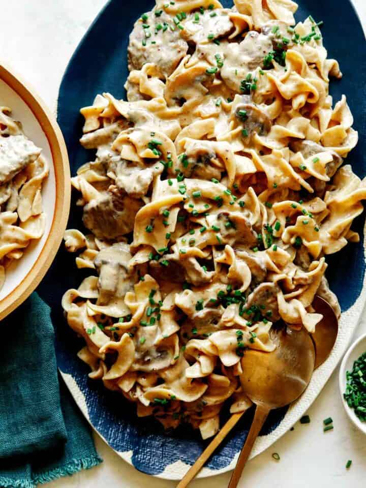 Beef Stroganoff recipe on a platter with chives on top.