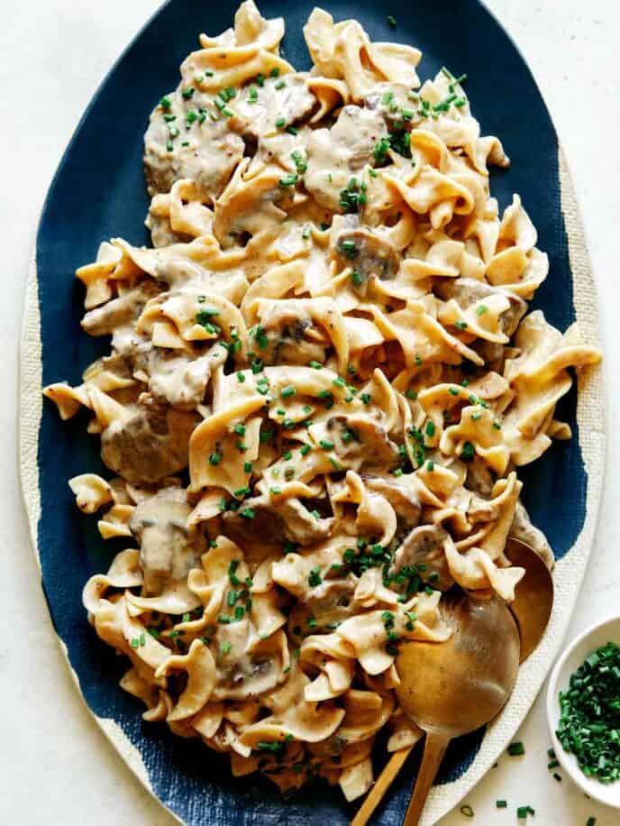 Beef Stroganoff on a platter with chives on top.