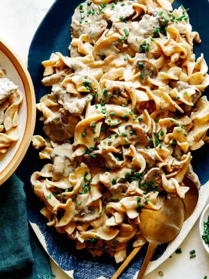 Beef Stroganoff on a platter with chives on top.