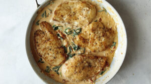 A skillet with tuscan chicken recipe in it.