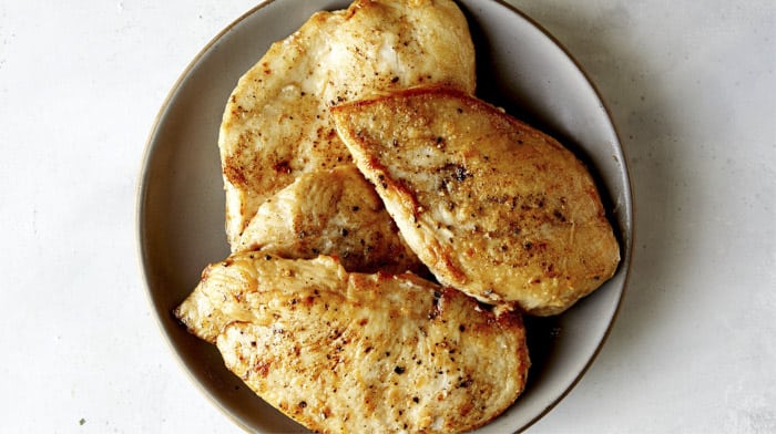 Freshly cooked chicken resting on a plate.