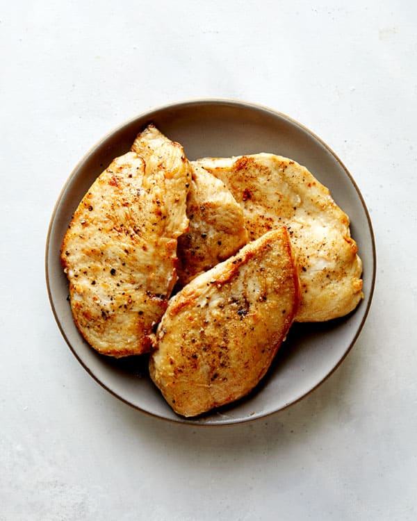 Seared chicken resting on a plate.