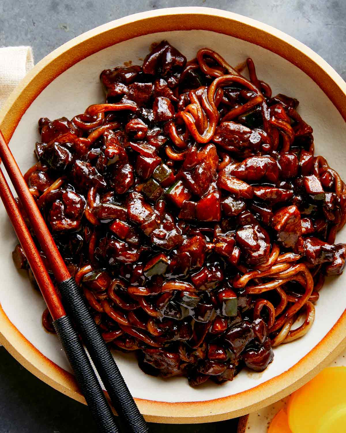 Jajangmyeon in a bowl with chopsticks on the side.