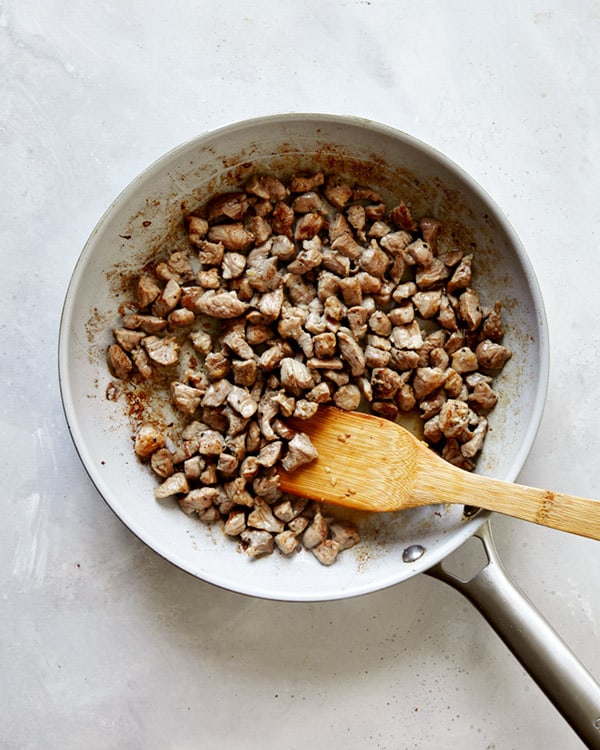 Cooking pork in a skillet to make  Jajangmyeon. 