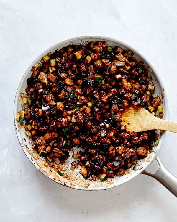 Black bean paste in a skillet mixed with veggies and pork and shrimp.