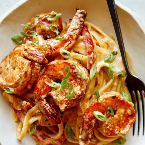 Cajun shrimp pasta recipe in a bowl with a fork on the side.