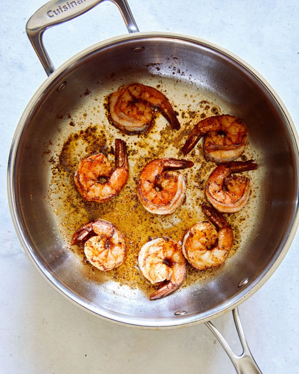 Cajun shrimp cooking in a skillet.