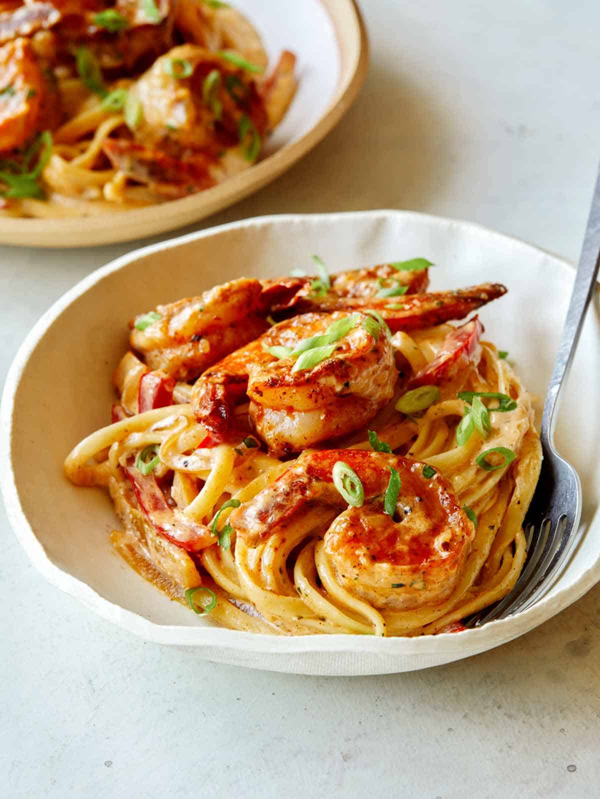 Cajun shrimp pasta in a bowl with a fork. 