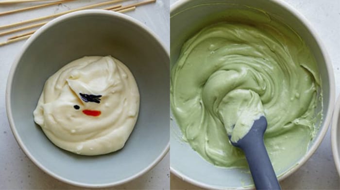 Frosting in two bowls being colored with food coloring.