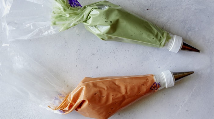 Frosting bags with orange and green frosting.
