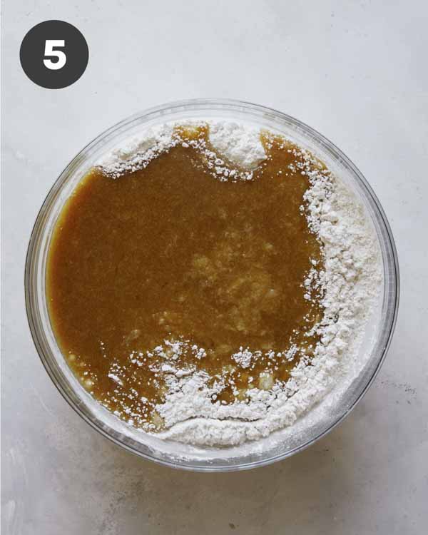 Carrot cake batter in a bowl with flour.