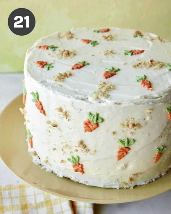 Carrot cake with mini carrots piped on it.