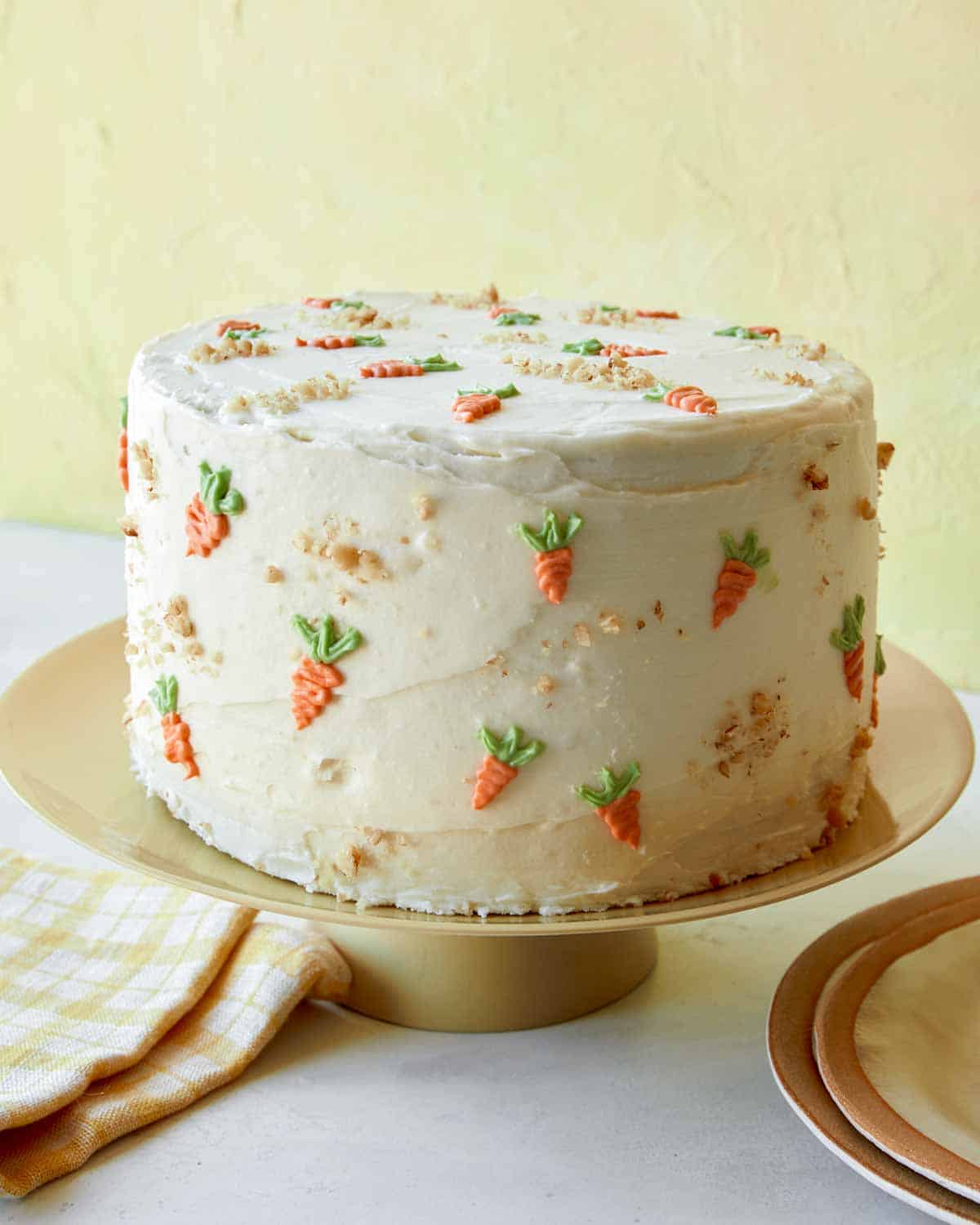 A carrot cake with cream cheese frosting on a plate.